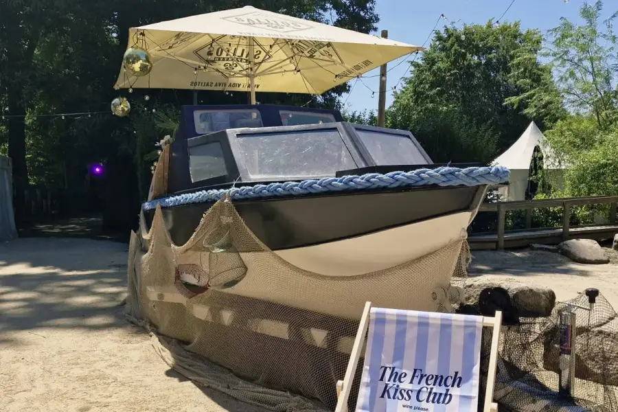 De Gestrande Sloep: a boat on the sand turned into a bar, with fishing nets, disco balls, a parasol and a striped deckchair