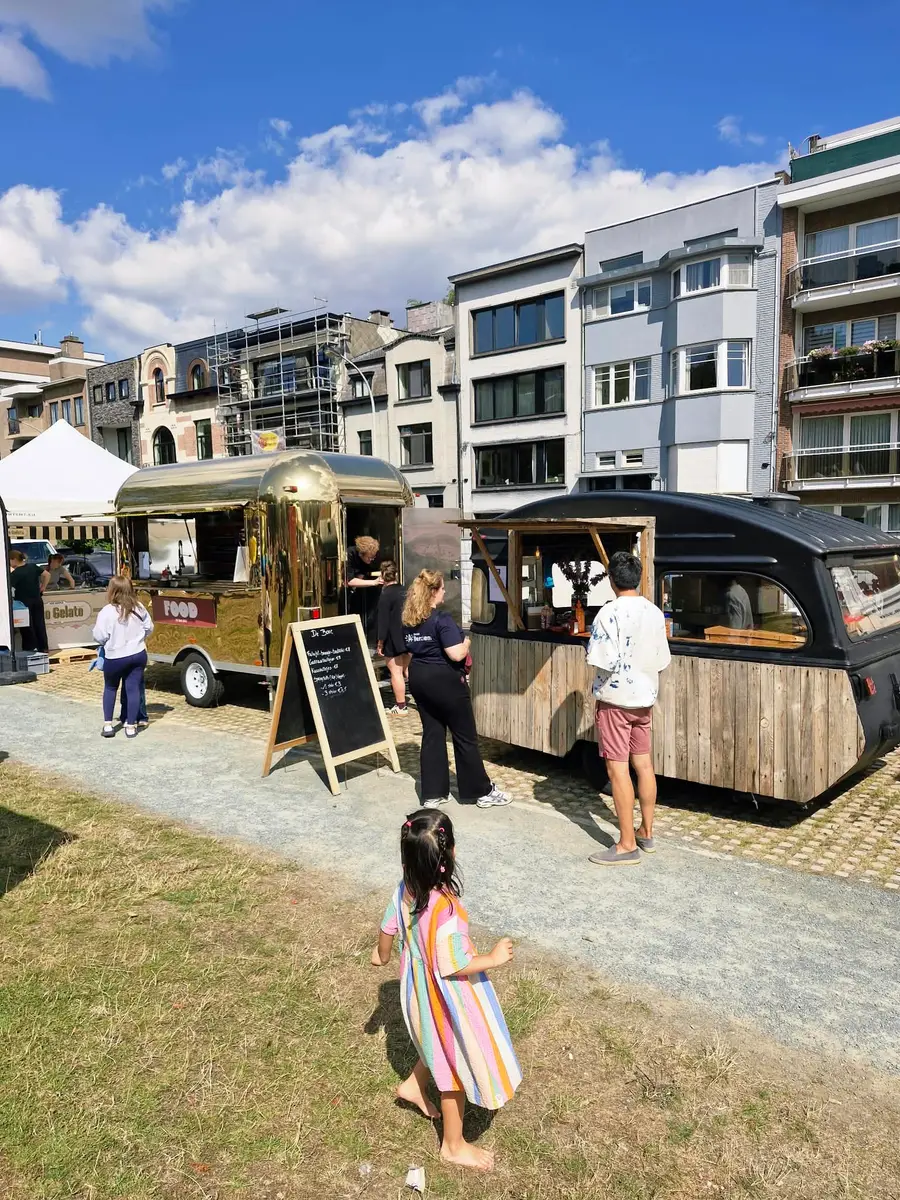 Golden Airstream and wooden caravan bar on a sunny day, with a child walking past