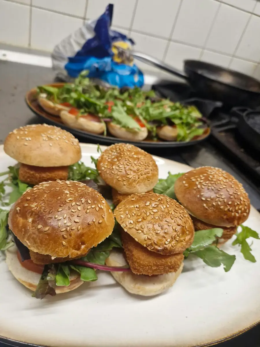 Plate of mini burgers and a bite with rocket